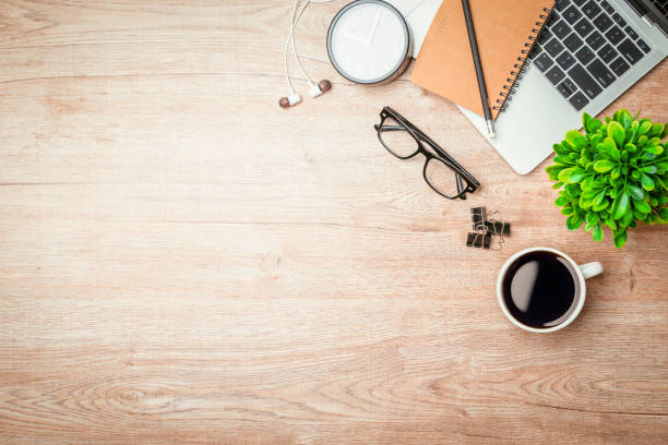 istock Work from home. desk office with laptop, blank notepad, coffee cup and pen on wood table. Flat lay top view copy spce. 1347150281