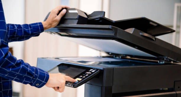 istock Businessmen press button on the panel for using photocopier or printer for printout and scanning document paper at office. 1347150287