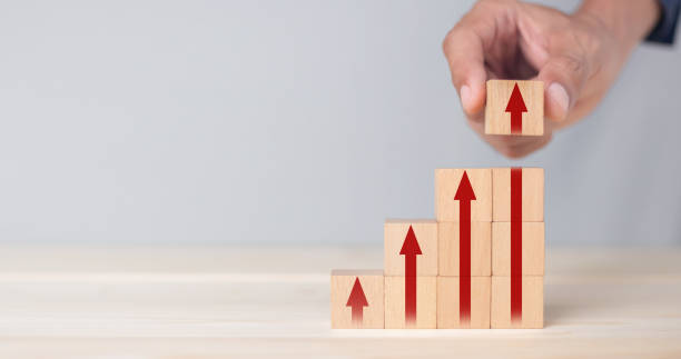 istock Growth graph and arrows ladder career path for business growth success process concept.Hand arranging wood block stacking as step stair with arrow up. 1347150357