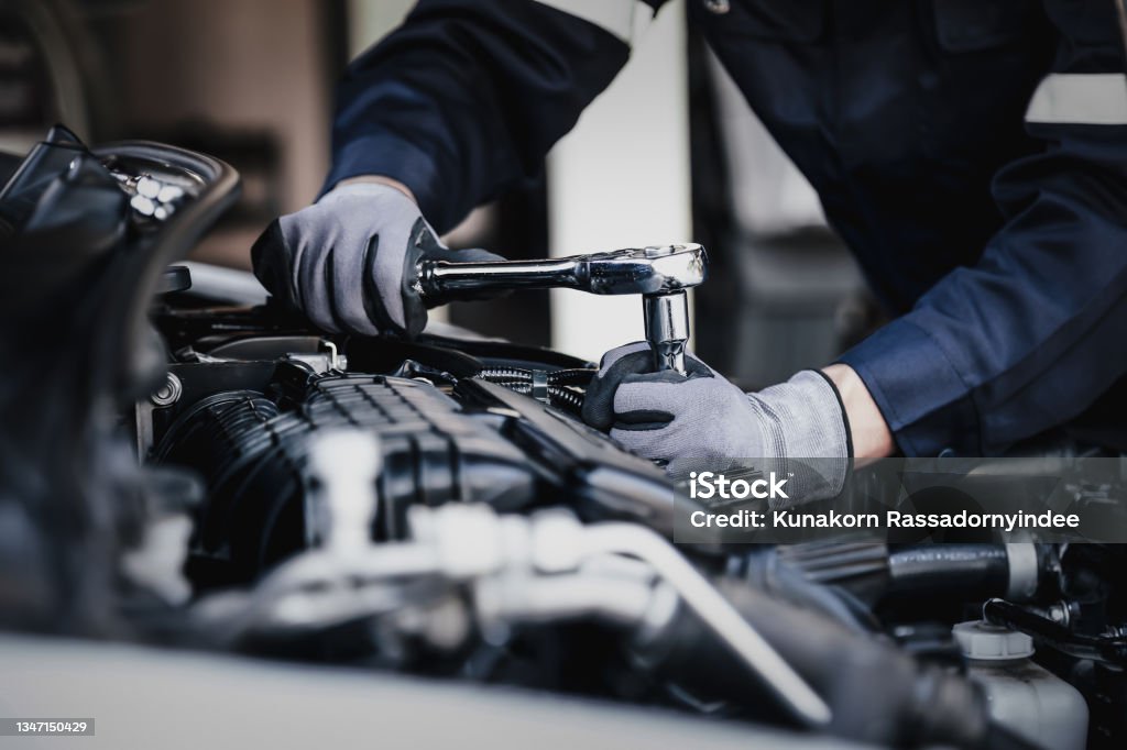 Professional mechanic working on the engine of the car in the garage. Professional mechanic working on the engine of the car in the garage. Car repair service. The concept of checking the readiness of the car before leaving. Auto Repair Shop Stock Photo