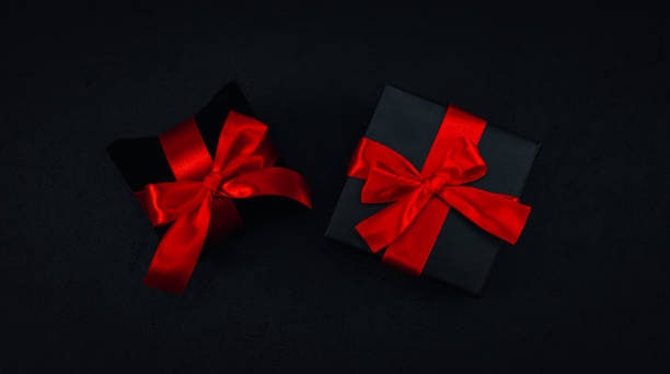istock Two black small gift boxes with a red ribbon tied in a bow 1347151962