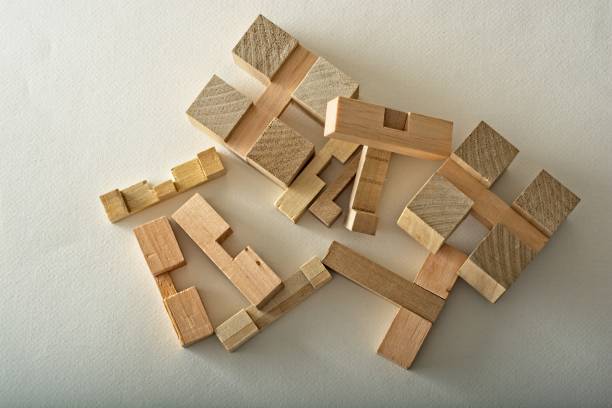 テクスチャー紙面に3次元木製パズルブロックピースの山 - cube puzzle three dimensional shape block ストックフォトと画像