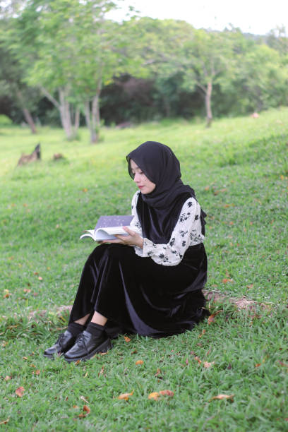 istock Young Hijab women sitting reading enjoying at park 1347156277