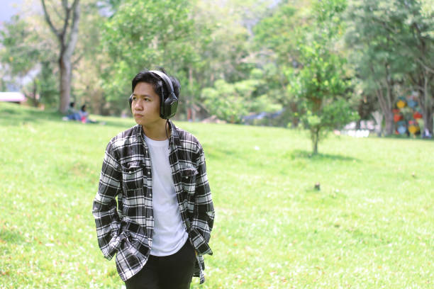 istock Young men enjoying at the park using headphone 1347156350