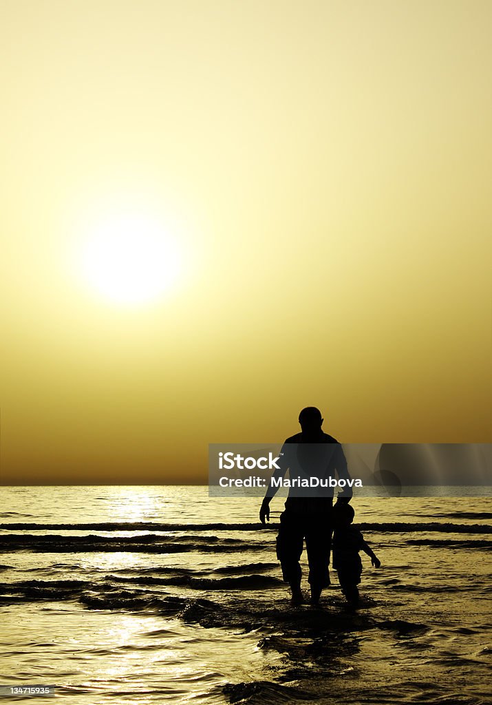 child with his father child with his father at sea during sunset Activity Stock Photo
