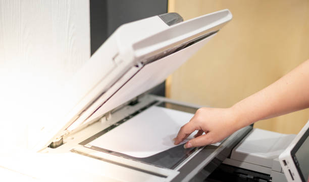 istock Business woman hand lay down or take papers from laser copy machine for process paperwork on laser print cartridge at the office. 1347160411