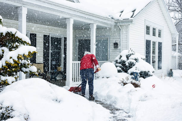 giacca rossa donna push shoveling winter blizzard snow - paletta foto e immagini stock