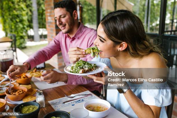 Young Latin Woman Eating Mexican Tacos On A Restaurant Terrace In Mexico Latin America Feeling Happy On A Summer Day Stock Photo - Download Image Now