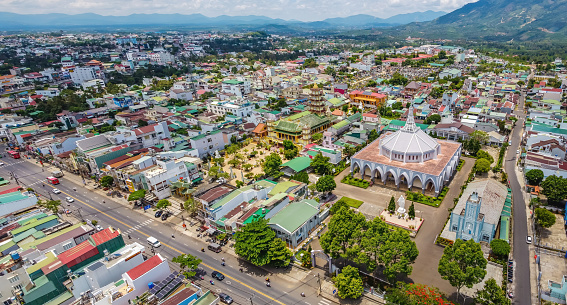 Aerial view of ancient Phuoc Hue pagoda is next to Bao Loc church on summer's day in Bao Loc, Vietnam, peaceful small town located on the plateau Di Linh, Lam Dong province. Travel and religion concept.