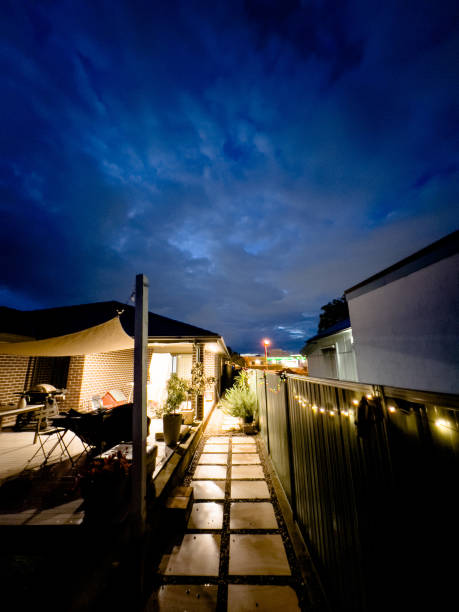 istock Outdoor back yard with modern home lit up and night sky 1347162093