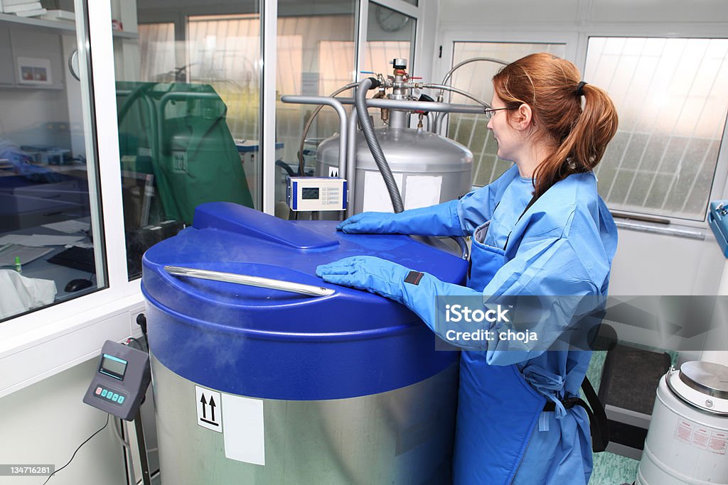Container with liquid nitrogen...doctor in hazmat suit at work Doctor working witk liquid nitrogen Container Stock Photo