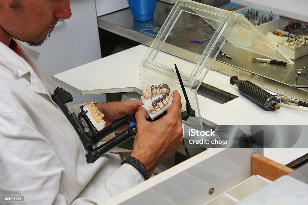 Manufacturing of dental prosthesis...young man,dental technician at work Dental technician Craftsperson Stock Photo