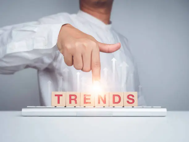 Photo of Trends Business Concept. Man hand pointing on words.