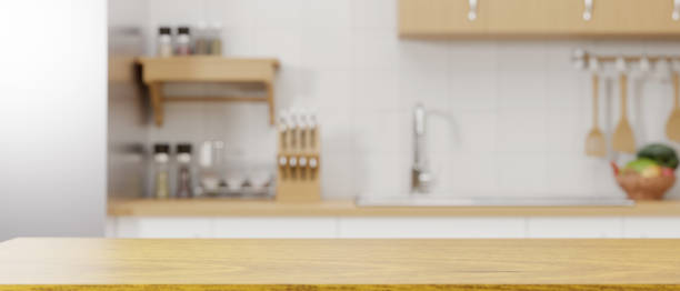 istock Wooden kitchen counter top for montage over blurred modern minimalist kitchen in the background. 1347166279