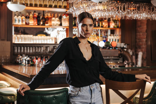 istock Classy young woman standing at the bar 1347168887