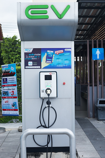 Electric vehicle charging station of PTT gas station in Bangkok Ladprao. In background are toilets.
