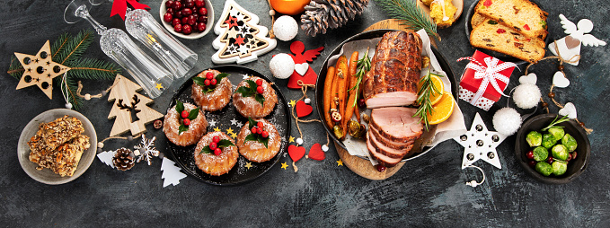 Christmas dinner table setting on dark background. Holiday season concept. Top view, flat lay, copy space, panorama