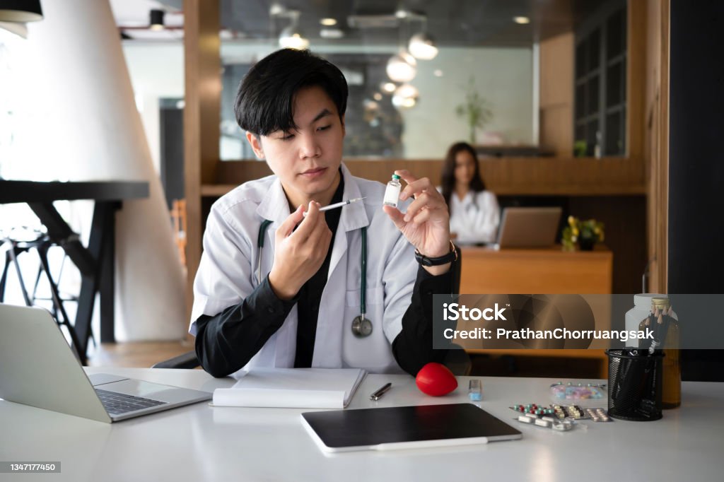 Doctor holding syringe and bottle of vaccine. Healthcare and Medical concept. 20-24 Years Stock Photo