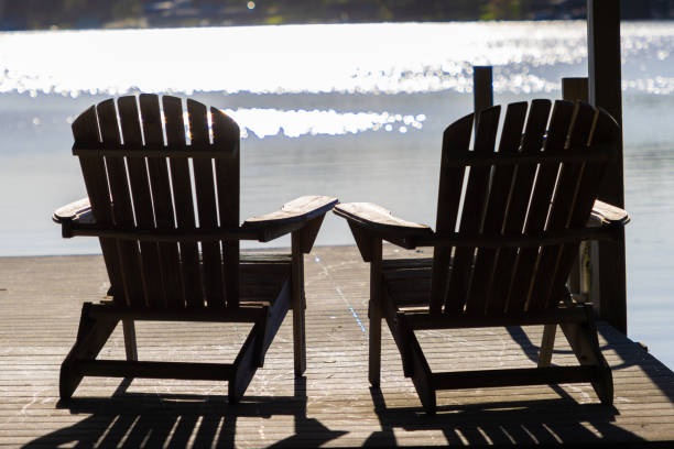 istock Two chairs overlooking lake in afternoon sun 1347177588