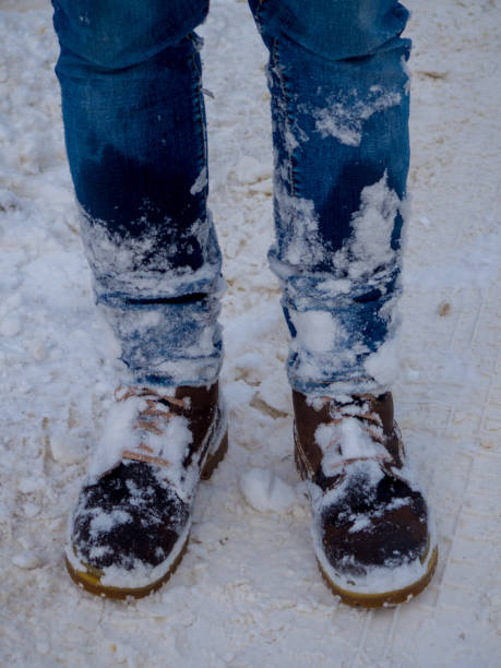 istock Man's legs in brown boots stay in the snow 1347179452