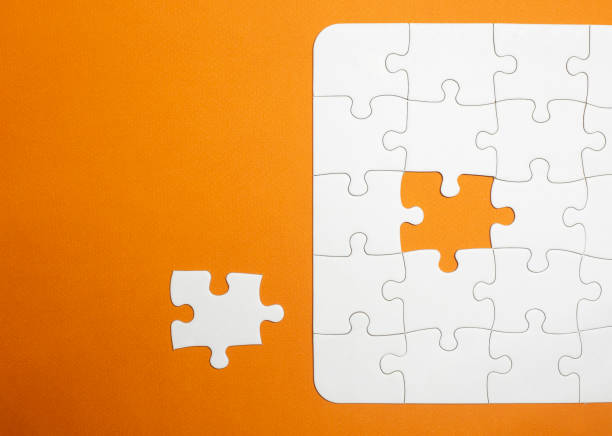 istock incomplete kit with the missing piece next to it to complete it. copy space. orange background. jigsaw of white pieces. teamwork. 1347180969