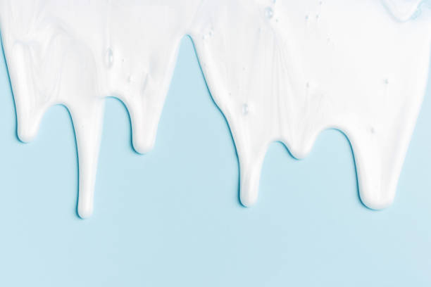 istock liquid moisturizing shampoo dripping down on blue background close-up. 1347181961