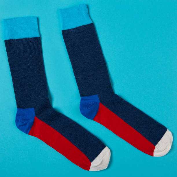 istock pair of blue socks with red soles, on cyan background, concept 1347183376