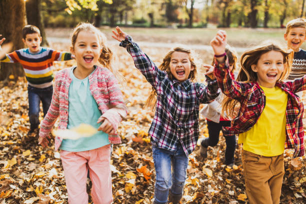 istock Playful kids having fun while running and screaming in autumn day. 1347184256