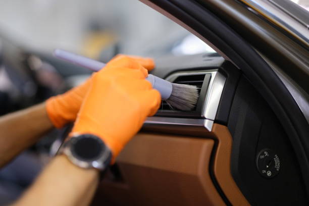 istock Gloved technician with brush to clean ventilation system in car closeup 1347189207