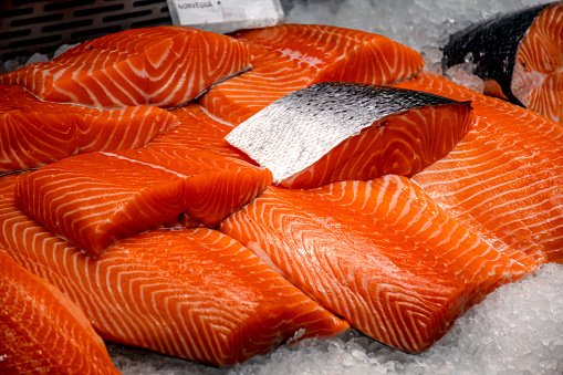 Fresh salmon steaks displayed on the ice in a fish market