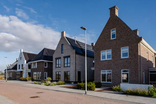 Photo of Dutch Suburban area with modern family houses, newly build modern family homes in the Netherlands, dutch family house, apartment house. Netherlands