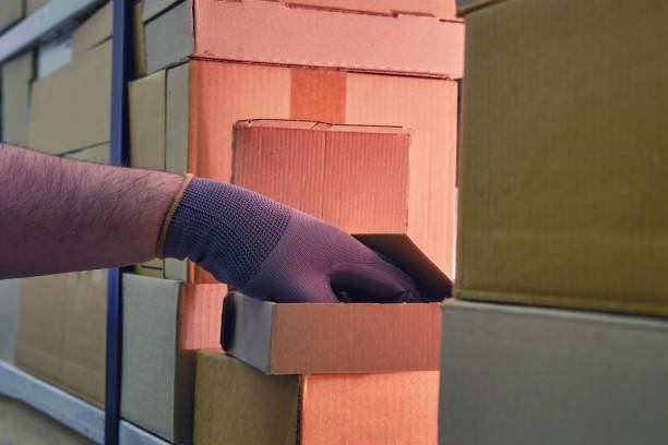 istock Theft from a box in a warehouse when sending goods by mail, hand in glove 1347191306