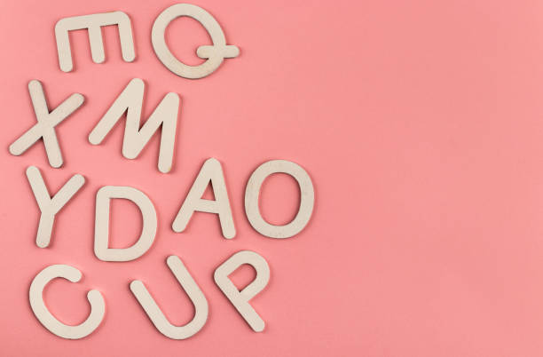 istock Wooden alphabet letters on pink paper background. 1347192464