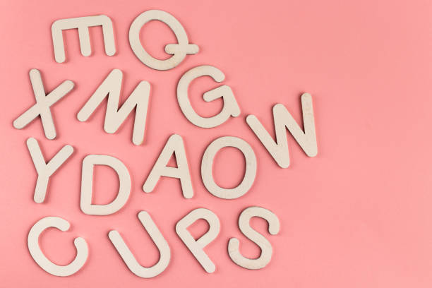 istock Wooden alphabet letters on pink paper background. 1347192467