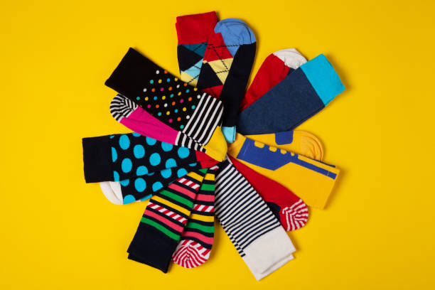 istock many colored socks with different patterns, laid out radially in the shape of a flower, on a yellow background, concept 1347193227