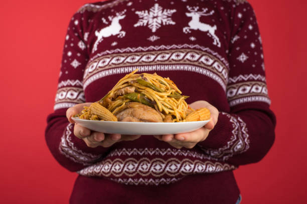고립 ��된 빨간 배경에 지방이 많은 음식의 큰 접시를 들고 빨간색과 흰색 크리스마스 스웨터에 소녀의 크롭 클로즈업 사진 - dieting ideas concepts only young women 뉴스 사진 이미지
