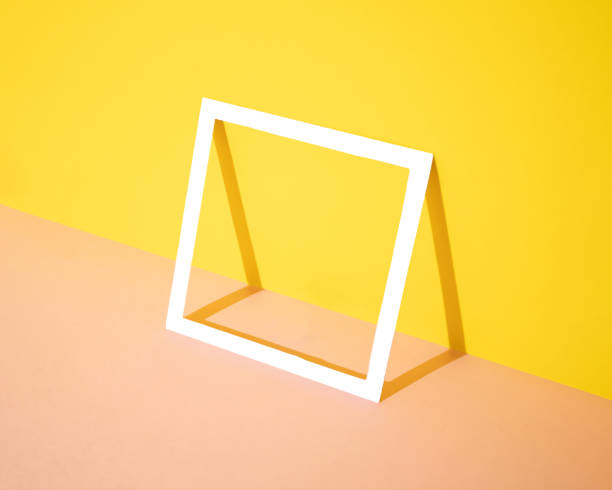 istock White square frame leaning against a yellow and pink background. Minimal design and concept. Copy space. 1347195201