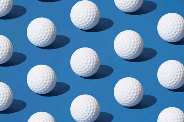 Arranged white golf ball on blue pastel background. Minimal design.