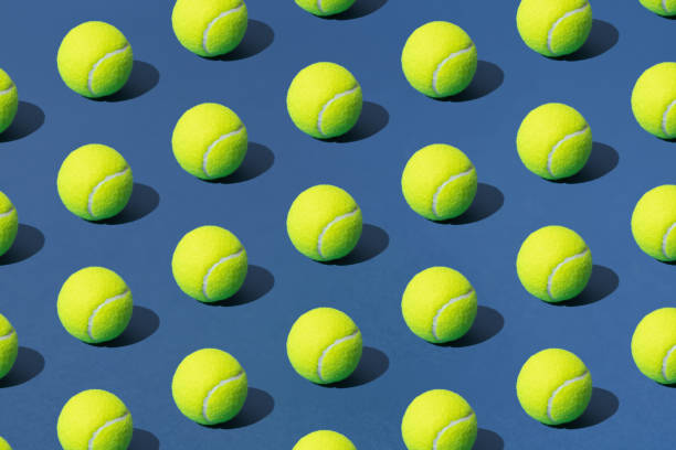 pelota de tenis verde dispuesta sobre fondo azul. patrón. - torneo de tenis fotografías e imágenes de stock