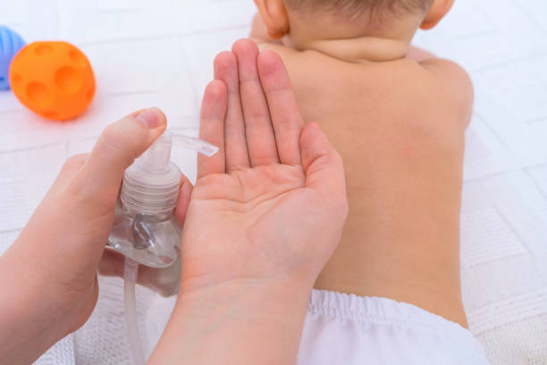 istock Newborn back massage, bottle with massage oil close up 1347197617
