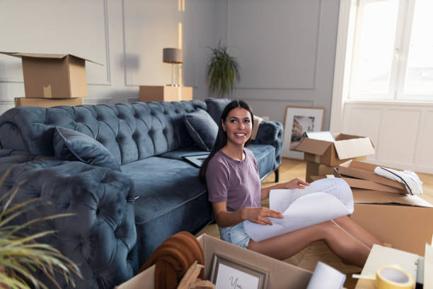 istock Happy woman analyzing house plan after relocating into new home. 1347199263