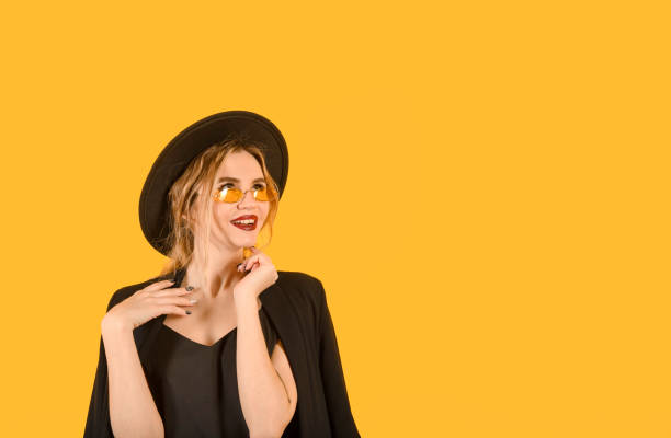 istock Young girl posing on yellow background side look amuse 1347199925