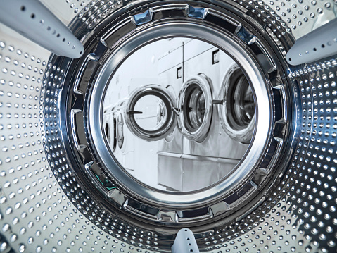 Looking out to a laundromat from inside of a washing machine