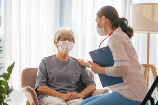 istock Doctor and senior woman wearing facemasks 1347203654