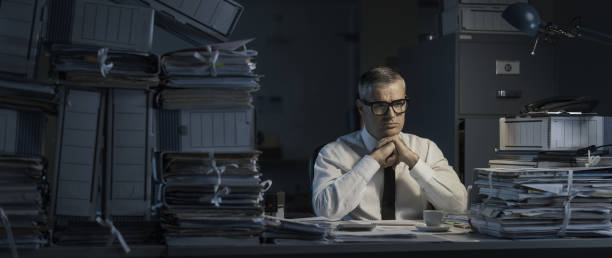 istock Pensive businessman overloaded with paperwork 1347204431