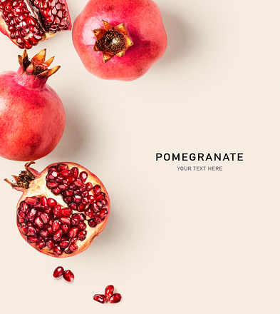 Fresh pomegranate creative layout on bright background. Healthy eating and dieting food concept. Winter fruits and berries composition. Top view, flat lay, design elements