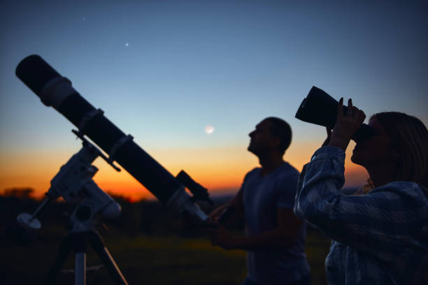 istock Couple stargazing together with a astronomical telescope. 1347205822