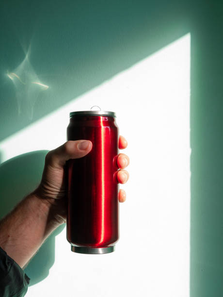 istock Red thermo can bottle in male hands against wall with harsh shadow.Hot tea coffee drinking in cold autumn winter weather 1347206079