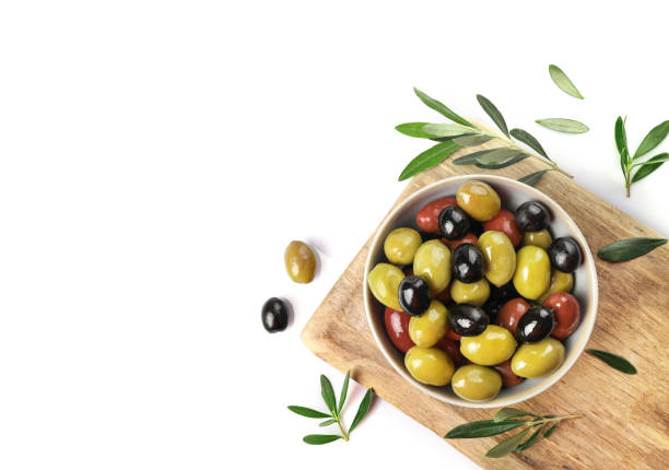 istock Green, red and black olives in bowl isolated on white background 1347207973