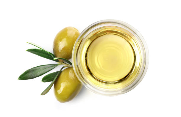 istock Olive branch and olive oil in a bowl isolated on white. Top view 1347207976